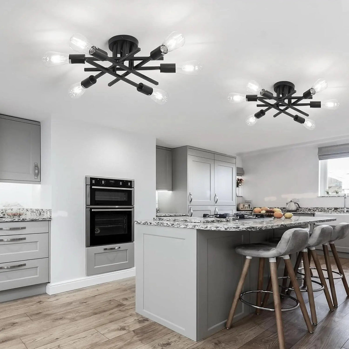 Modern kitchen with gray cabinets, black appliances, and a chandelier.