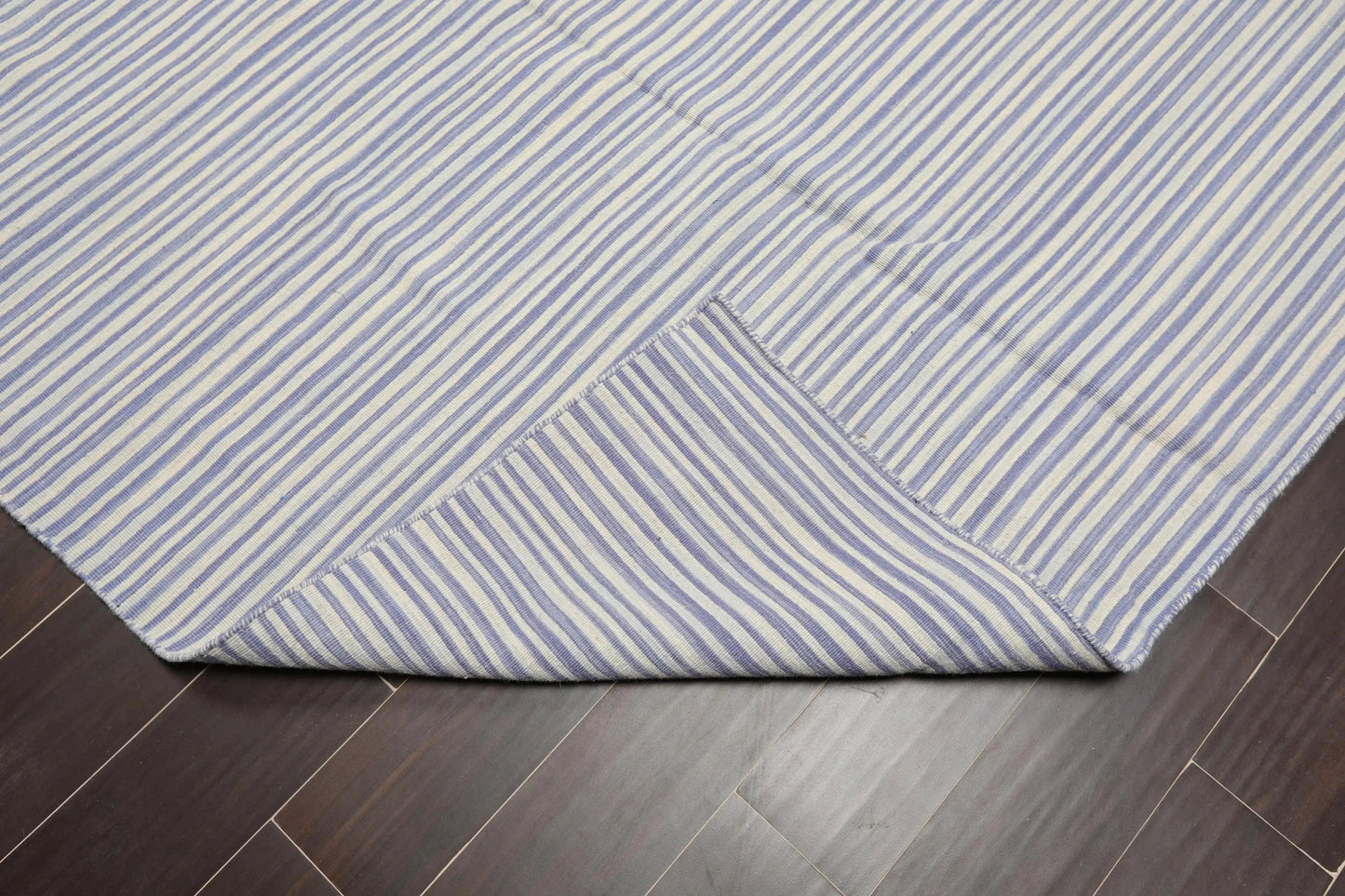 Blue and white striped rug on a wooden floor