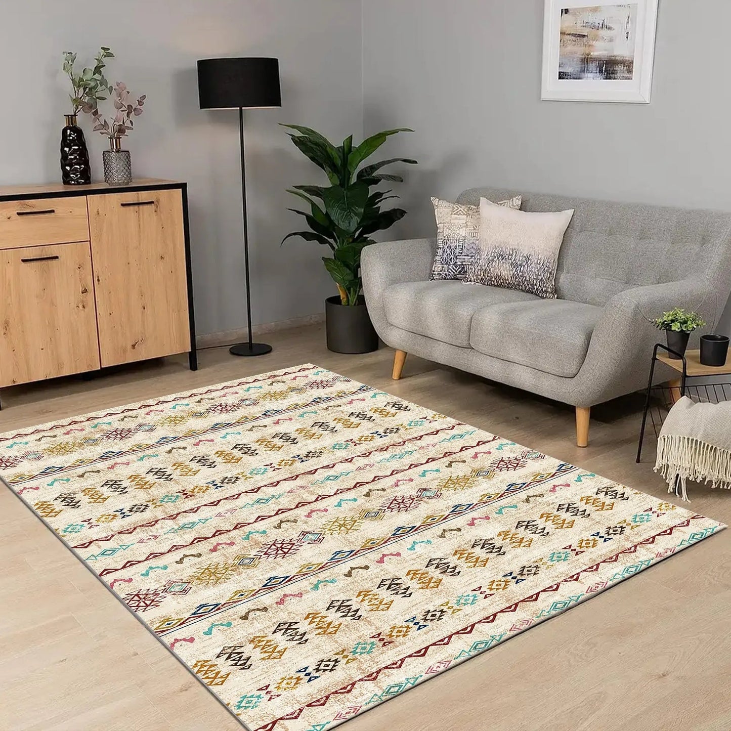 Living room with a patterned rug, gray sofa, wooden cabinet, and decorative items.
