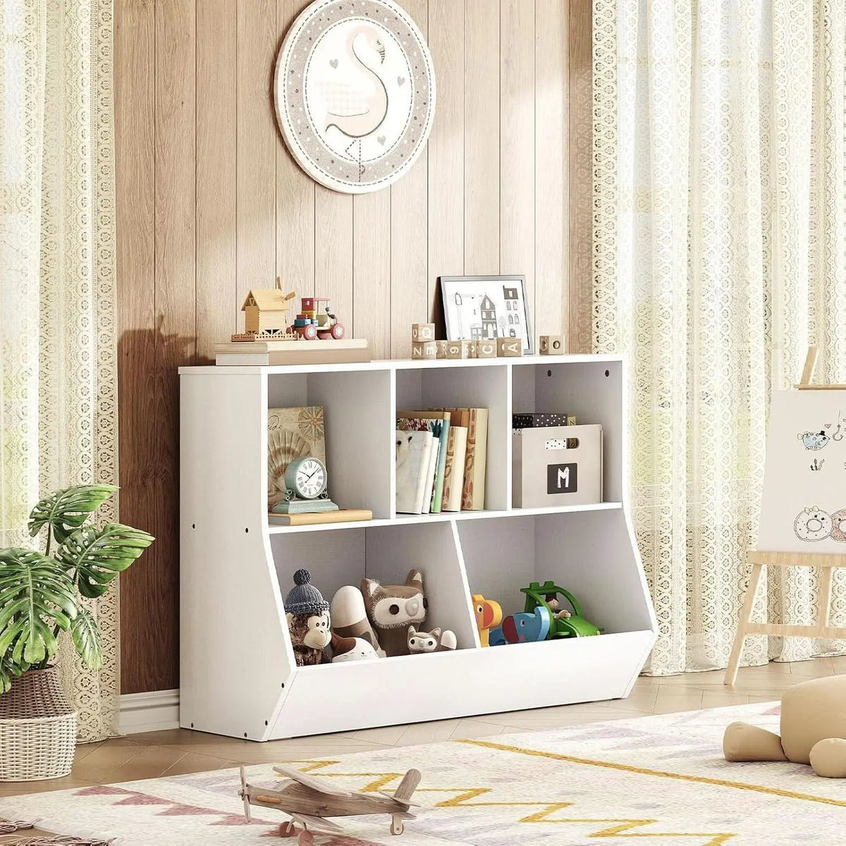 White bookshelf with toys and books in a room with wooden walls and curtains.