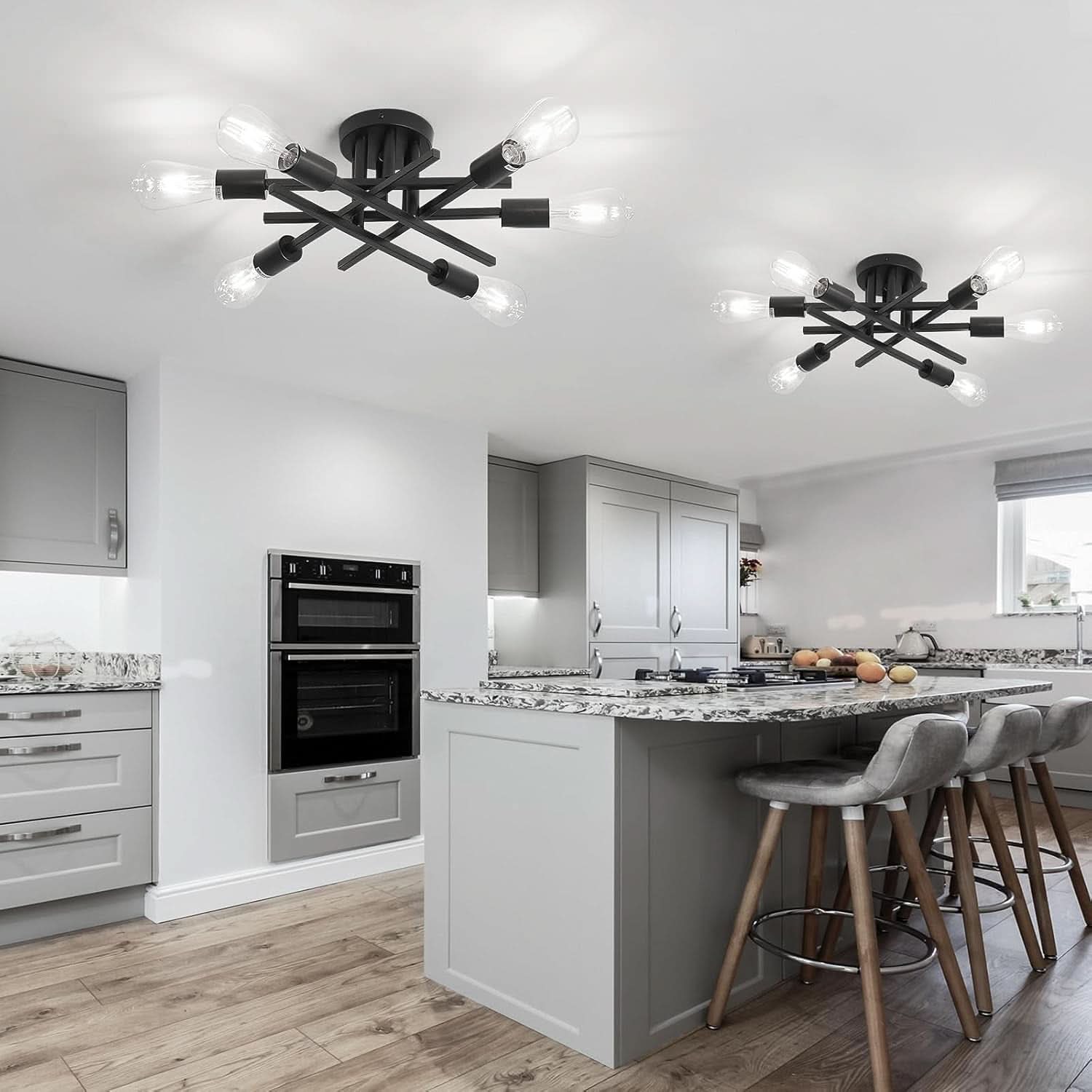 Modern kitchen with gray cabinets, black appliances, and a chandelier.