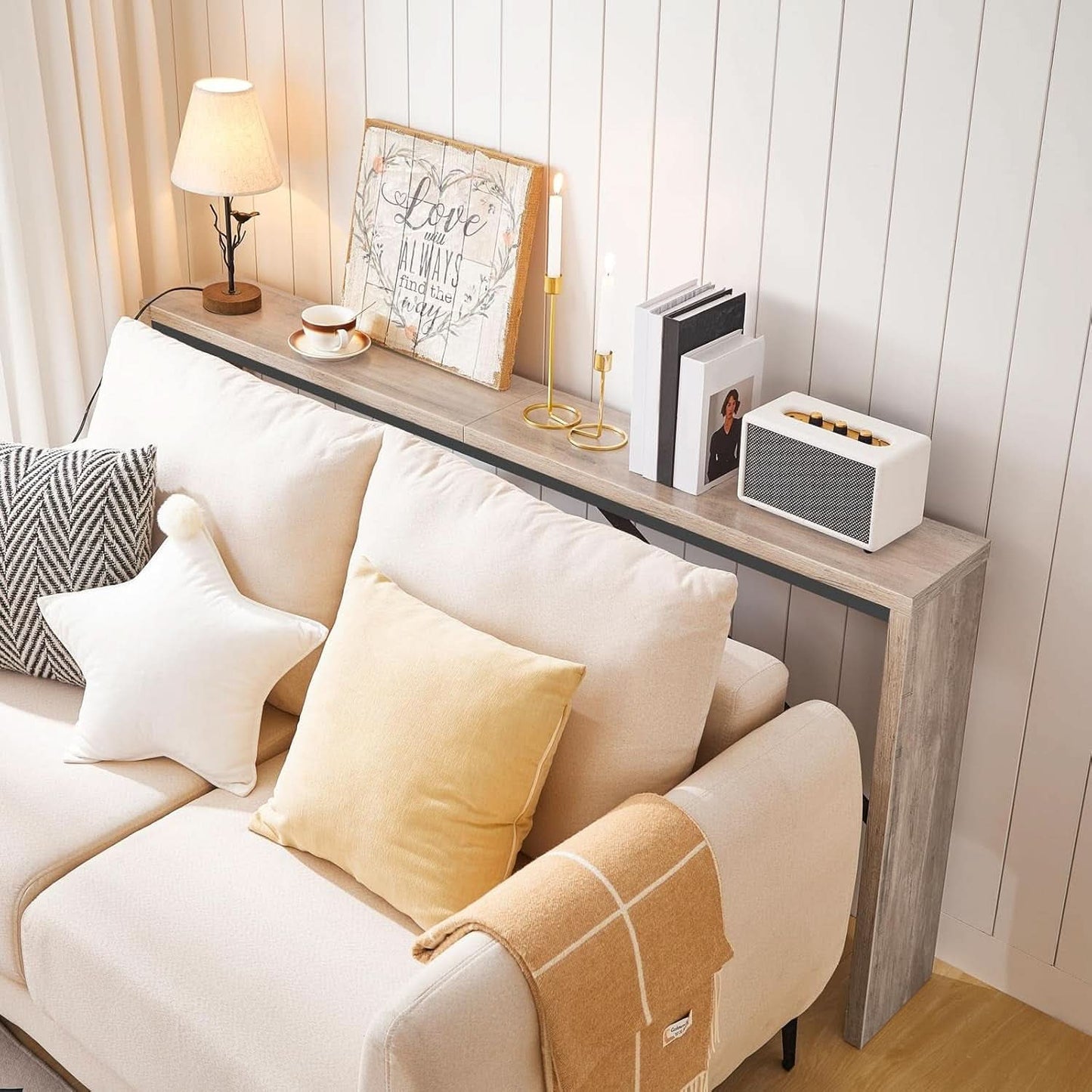 Cozy living room with a beige sofa, wooden side table, and decorative items.