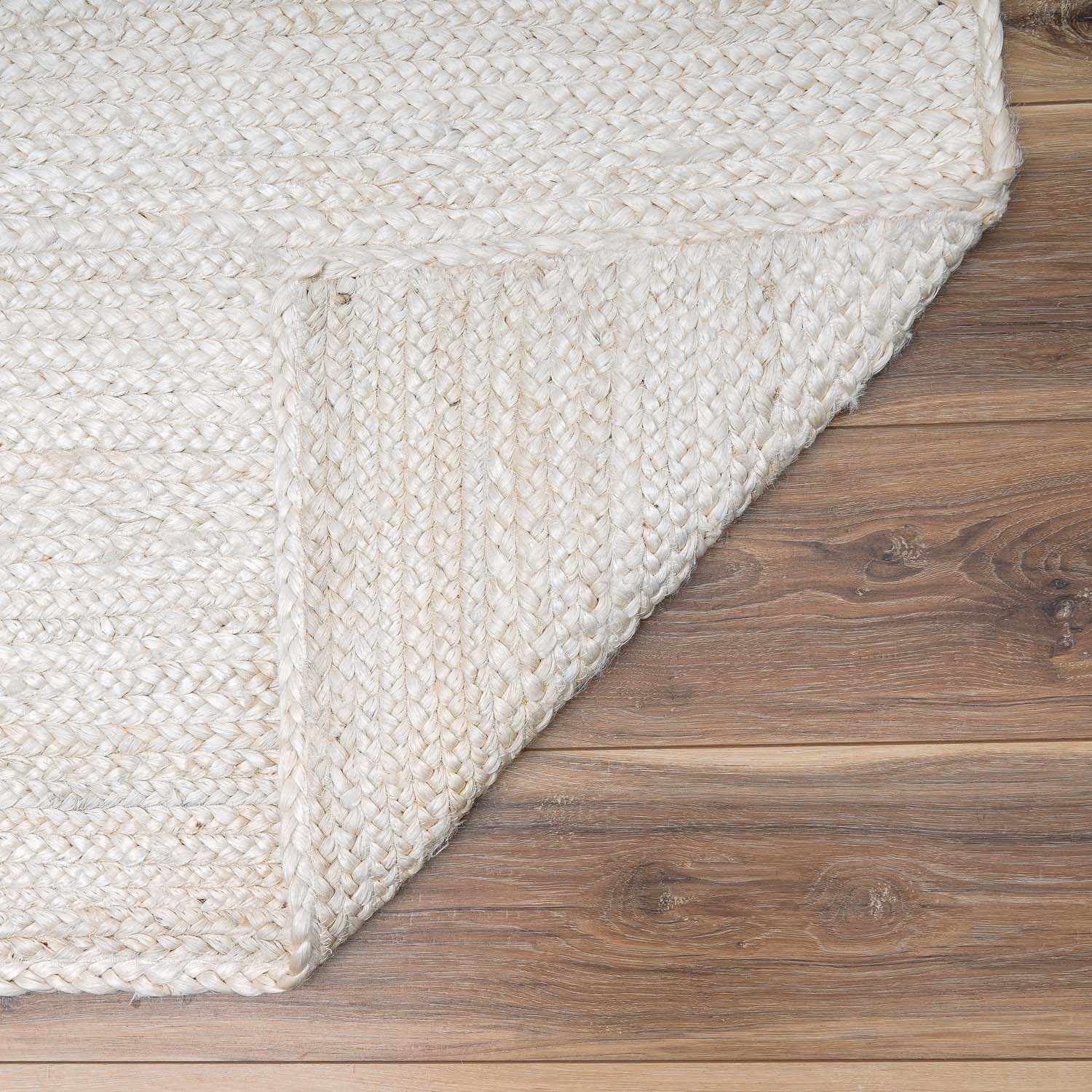 Close-up of a textured white rug on a wooden floor
