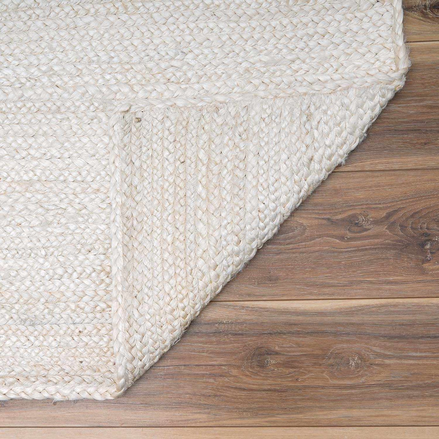 Close-up of a textured white rug on a wooden floor
