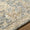 Close-up of a textured area rug with intricate patterns on a wooden floor.
