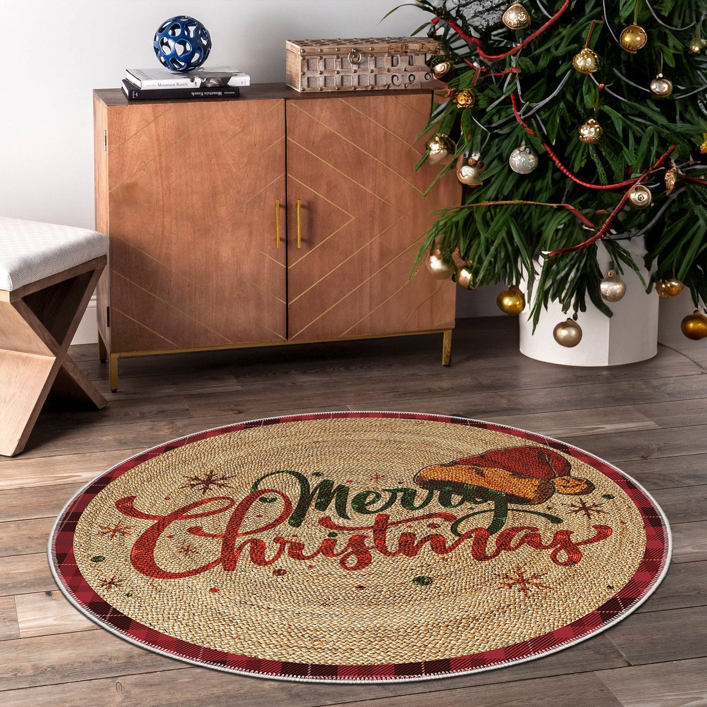 Round Christmas-themed rug with 'Merry Christmas' text in a room with a wooden cabinet and decorated tree.