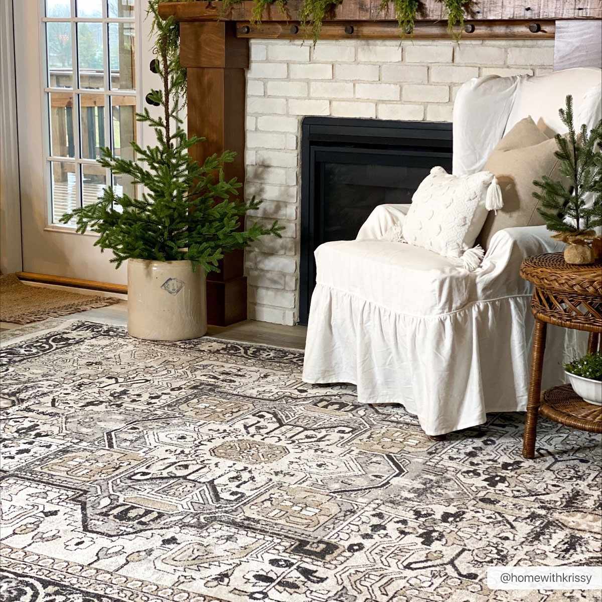 Living room with a white armchair, fireplace, and decorative rug.