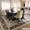 Dining room with a wooden table and chairs on a patterned rug.