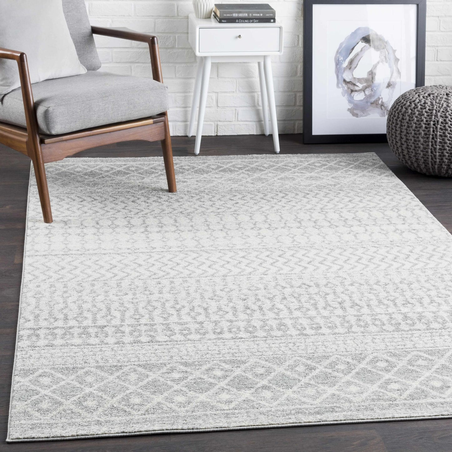 Living room with a gray patterned rug, chair, and side table.