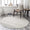 Round rug in a room with a chair and small table.