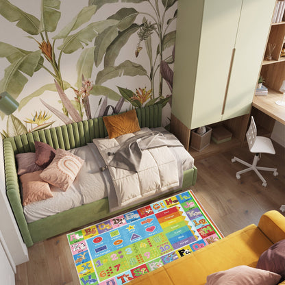 Children's room with green sofa, colorful rug, and plant-themed wallpaper.
