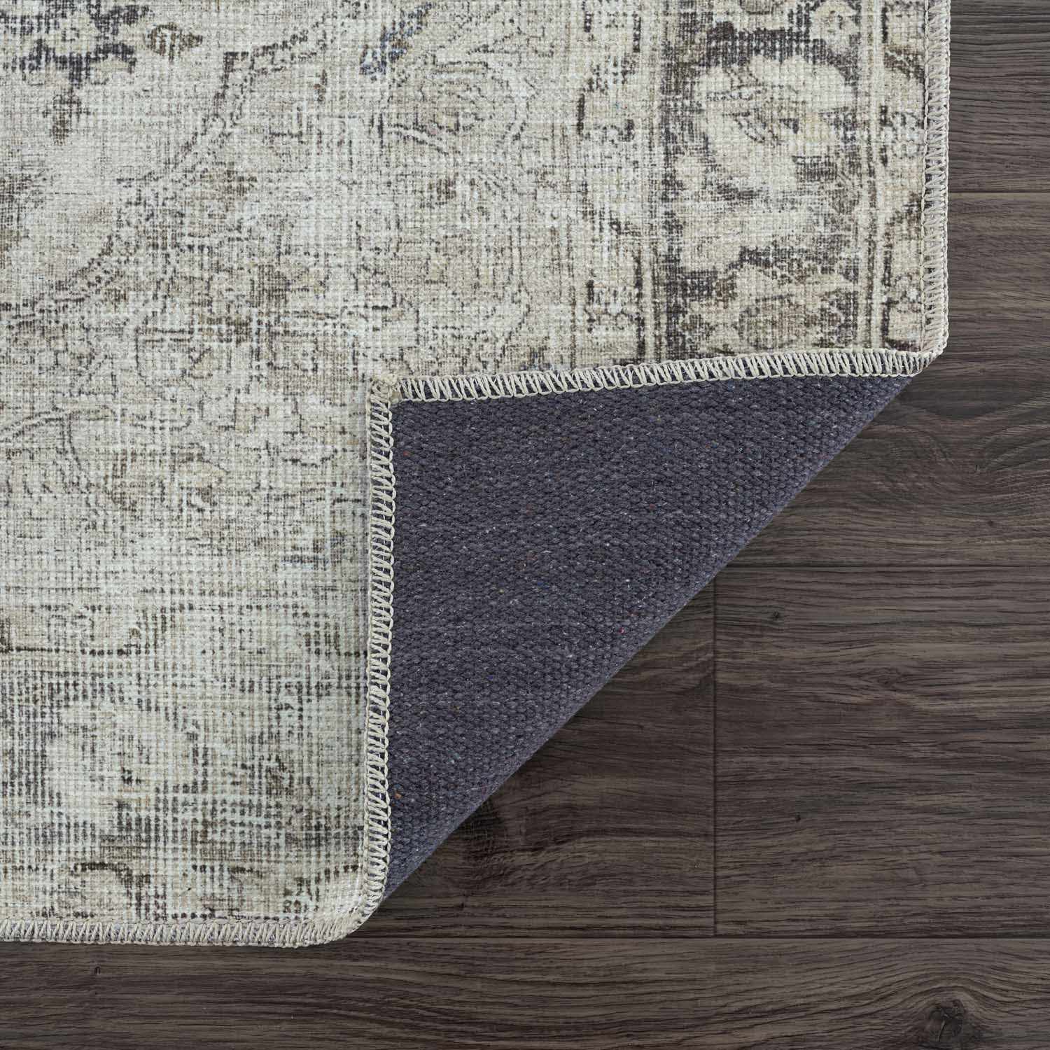 Textured rug with a dark gray border on a wooden floor