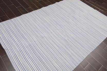 White rug with blue stripes on a wooden floor