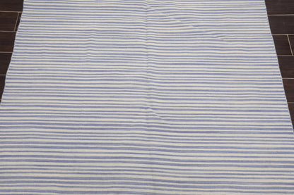 Striped rug with blue and white horizontal lines on a wooden floor.