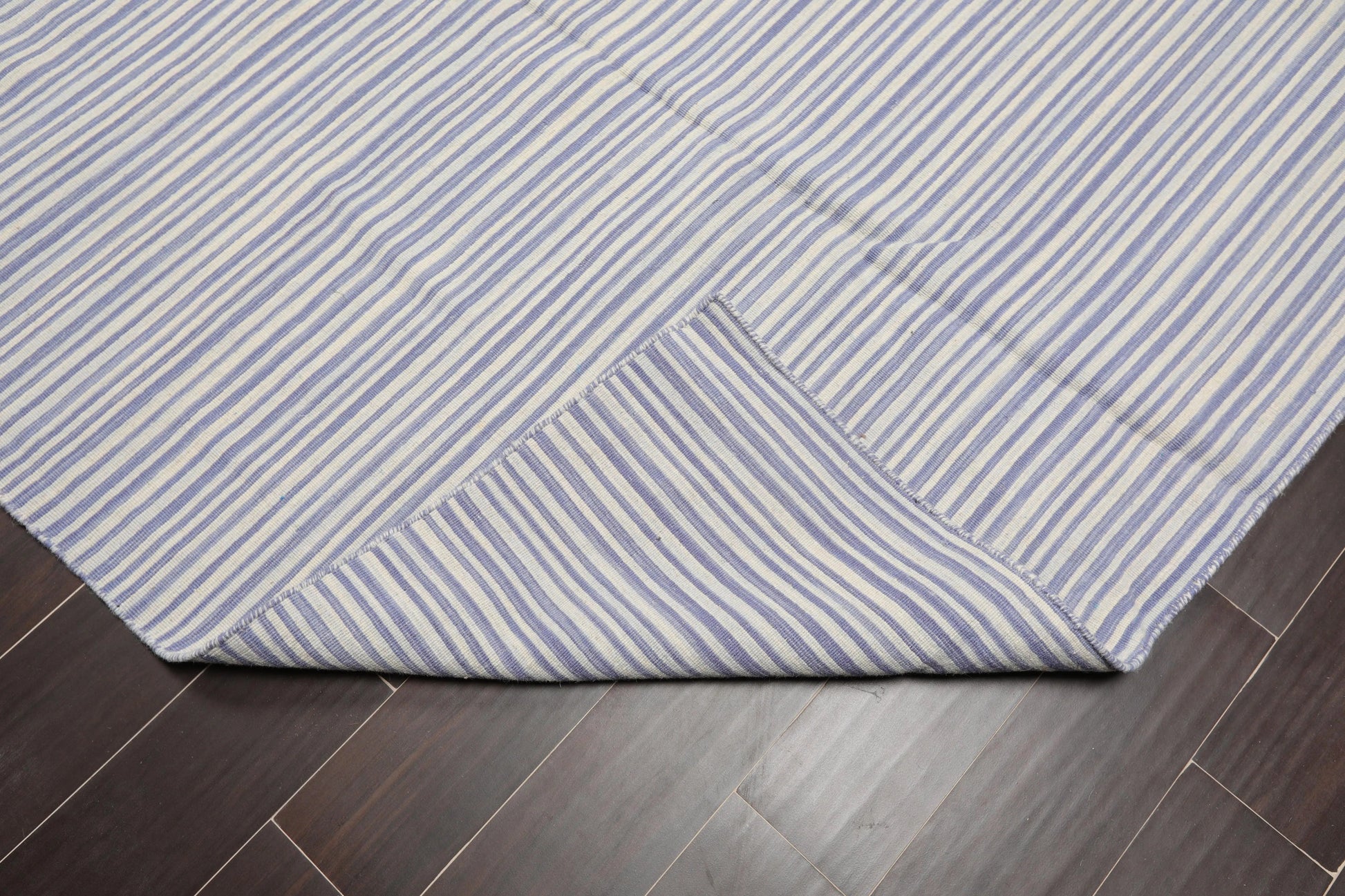 Blue and white striped rug on a wooden floor