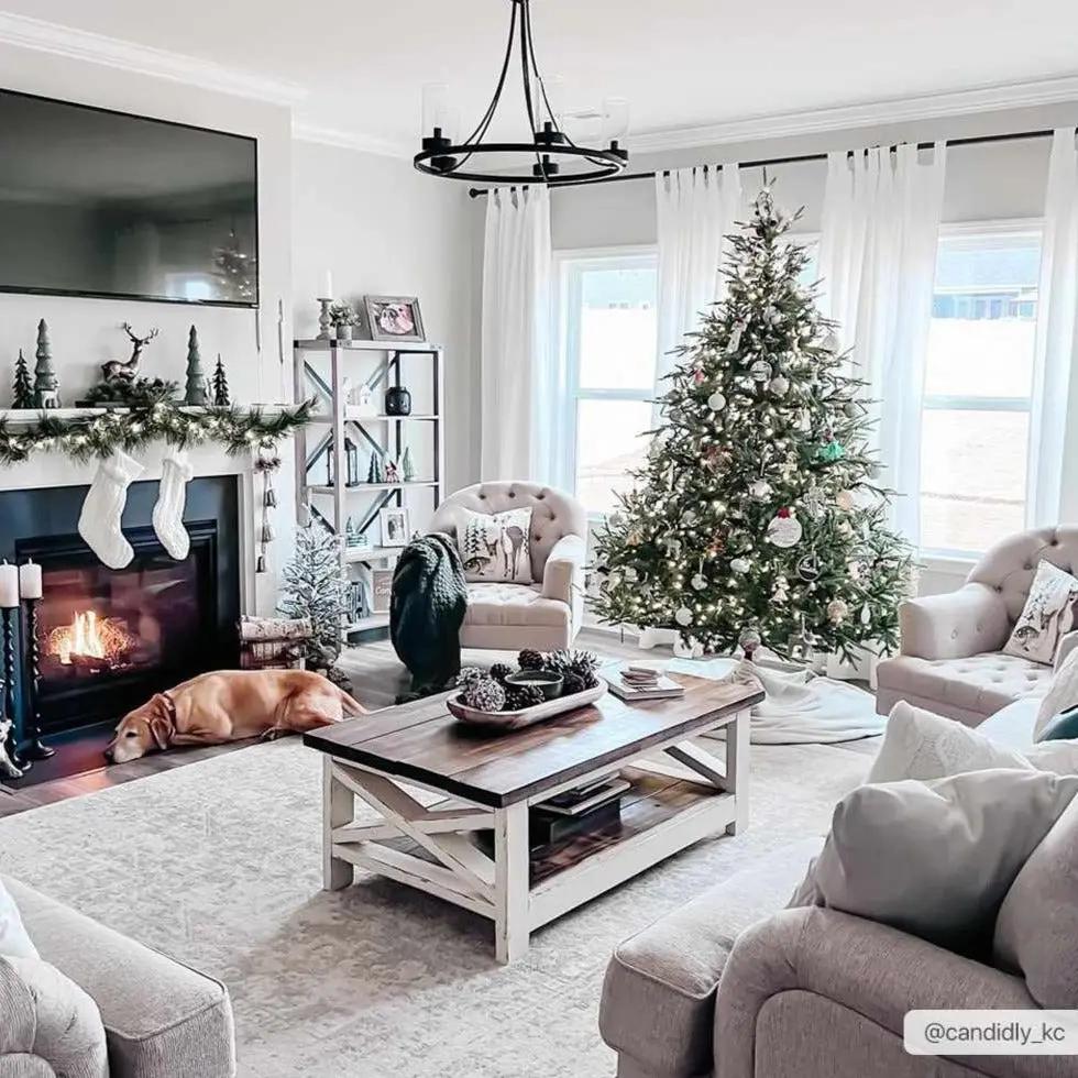 Cozy living room with Christmas decorations, including a tree, stockings, and fireplace.