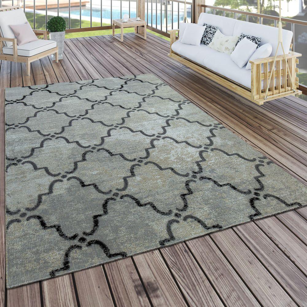 Patterned rug on a wooden deck with outdoor furniture in the background