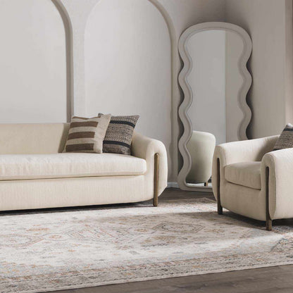 Beige sofa and armchair with decorative pillows in a stylish living room.