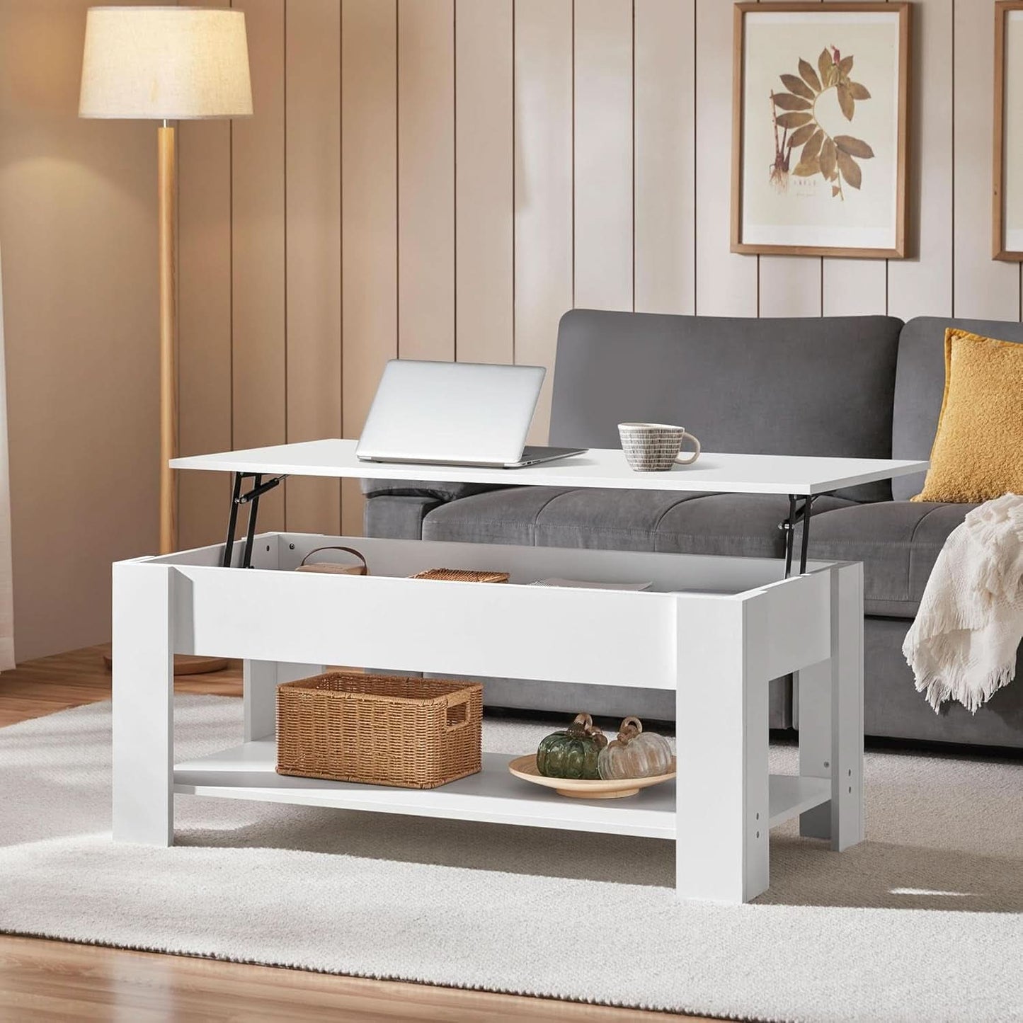 White coffee table with a laptop and decorative items in a living room setting.