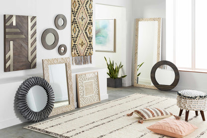 Living room with decorative mirrors, artwork, and a rug.