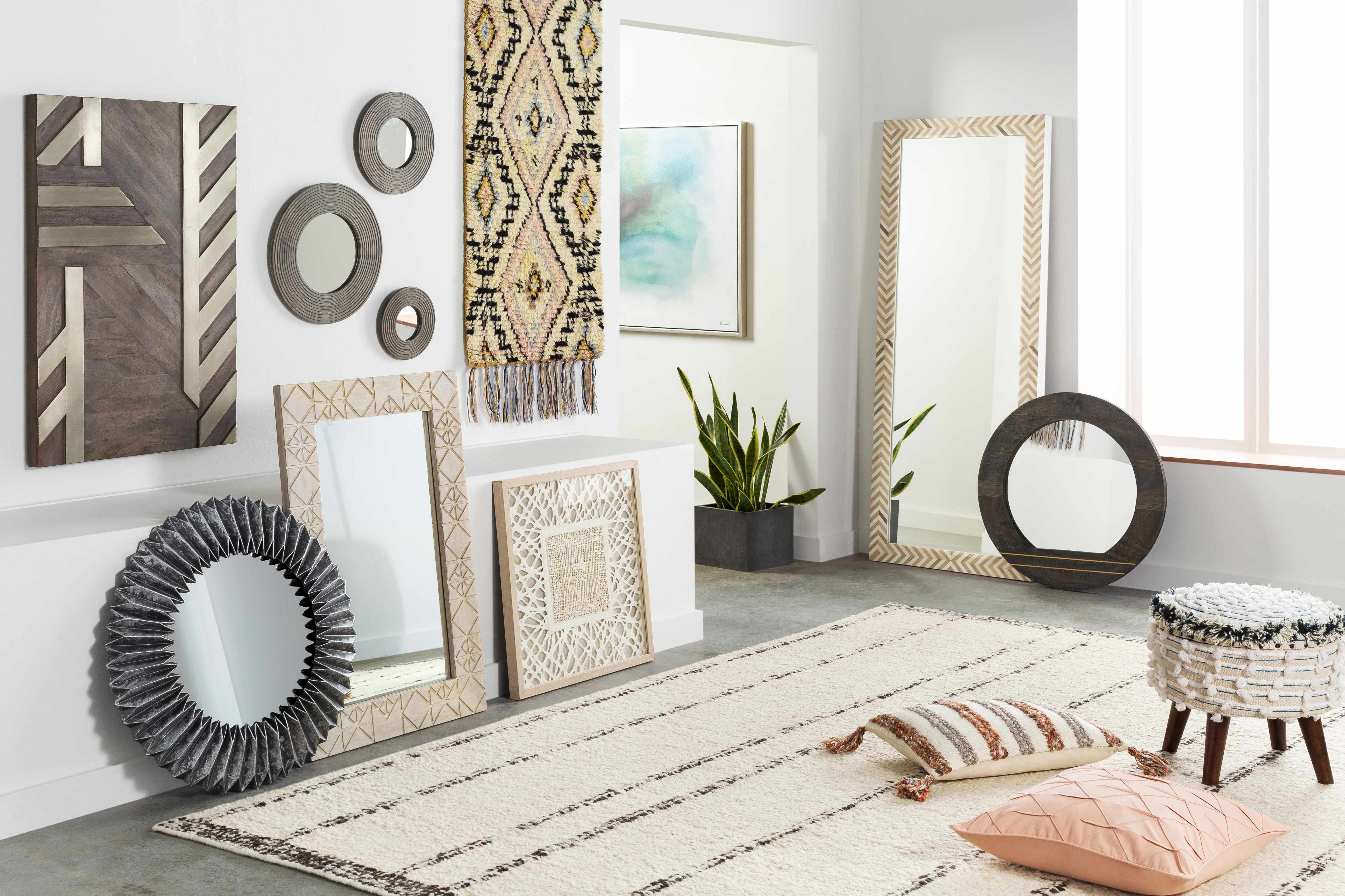 Living room with decorative mirrors, artwork, and a rug.