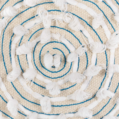Close-up of a textured round rug with concentric circles and tassels.
