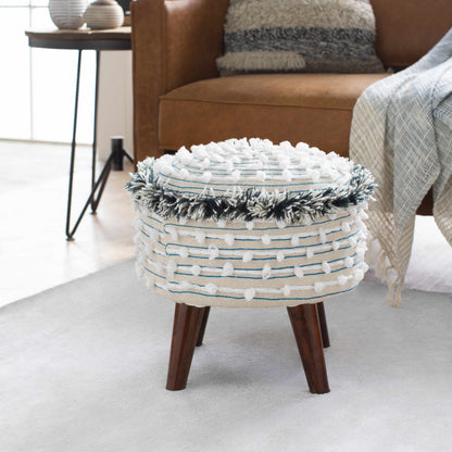 Decorative ottoman with woven top and wooden legs in a living room setting.
