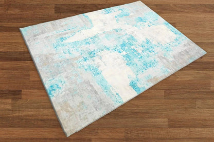 Rug with blue and beige abstract pattern on a wooden floor