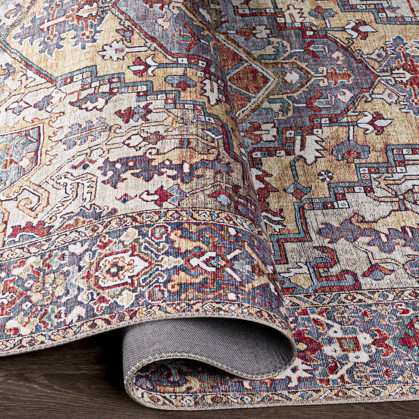 Close-up of a patterned rug with intricate designs on a wooden floor.