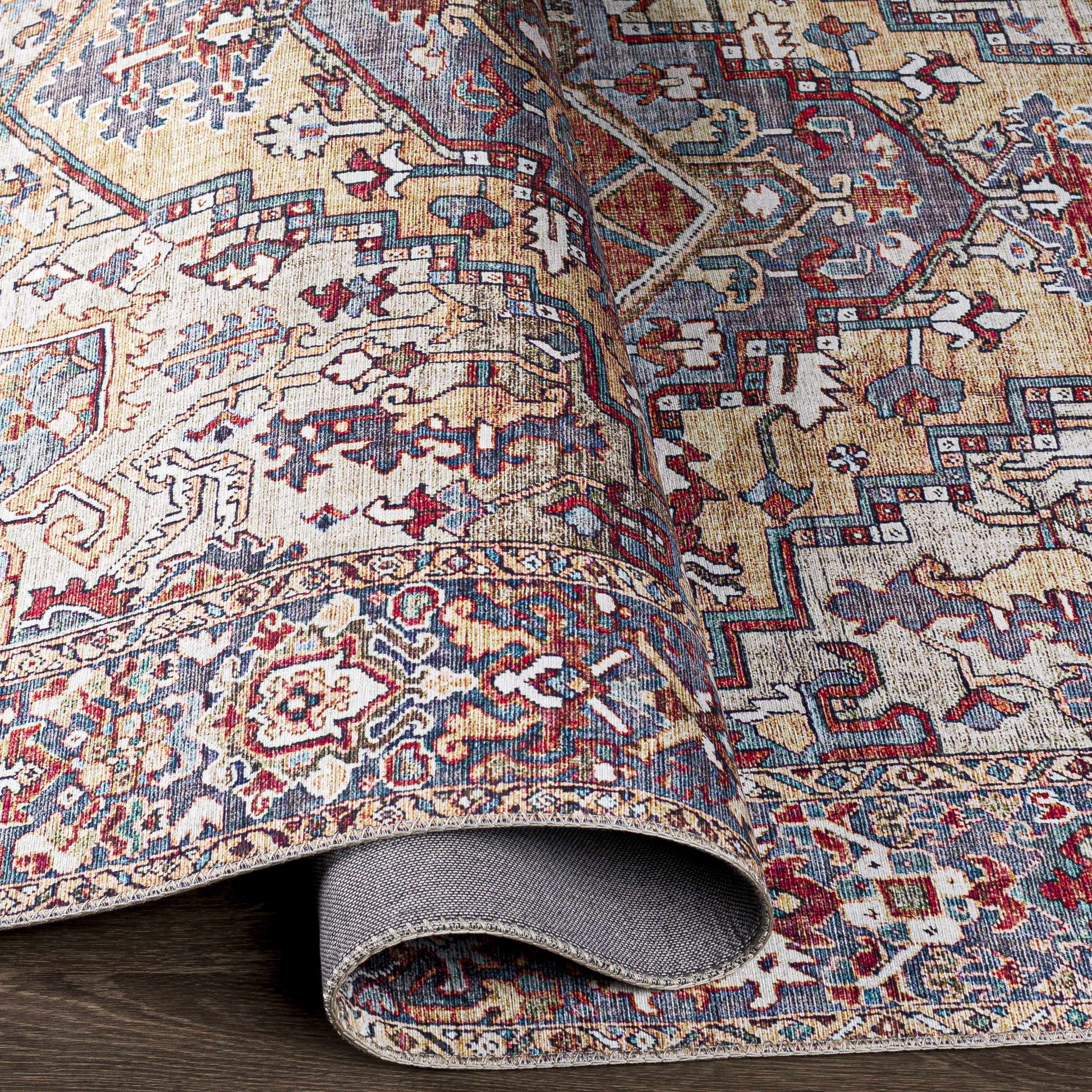 Close-up of a patterned rug with intricate designs on a wooden floor.