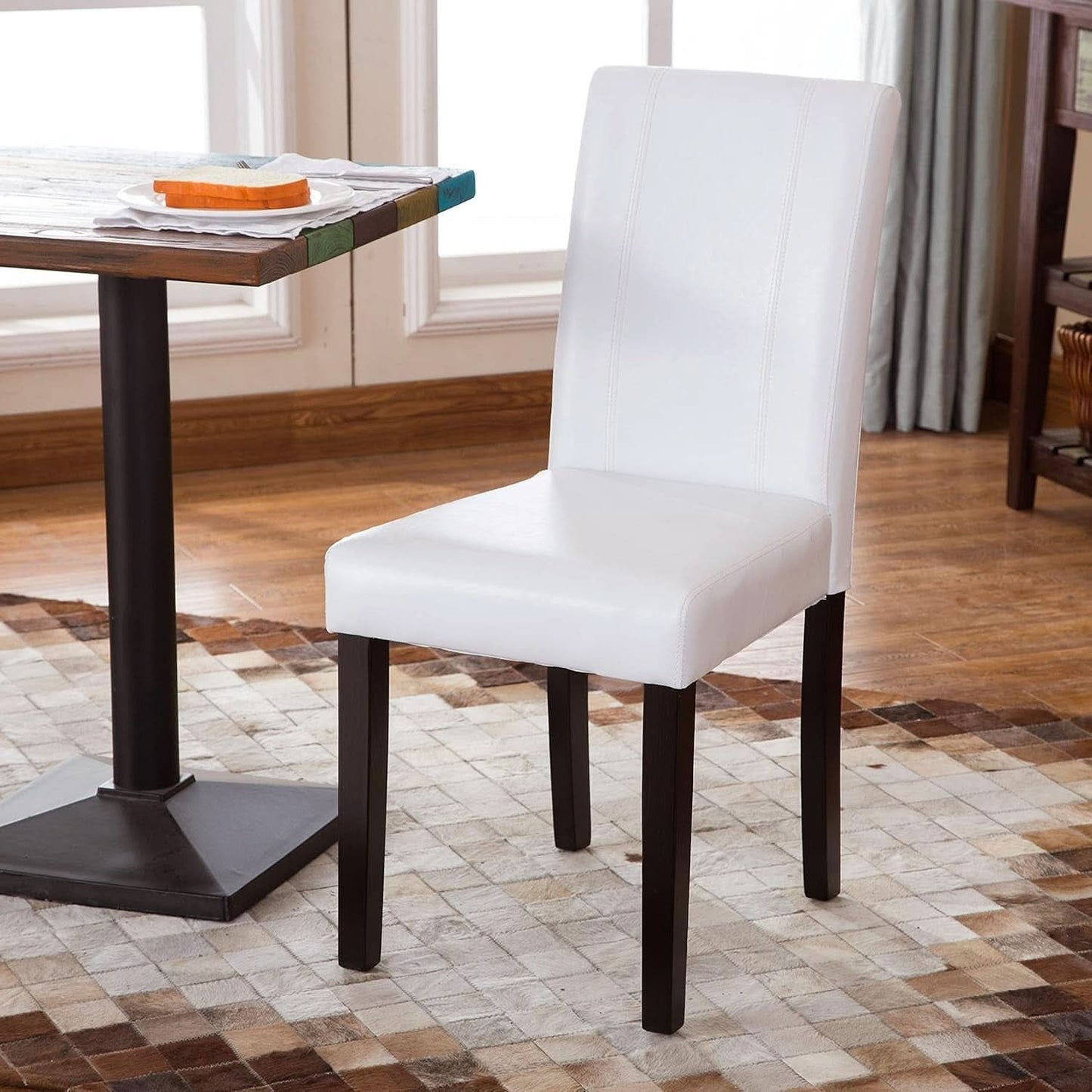 White chair with dark wooden legs in a dining room setting