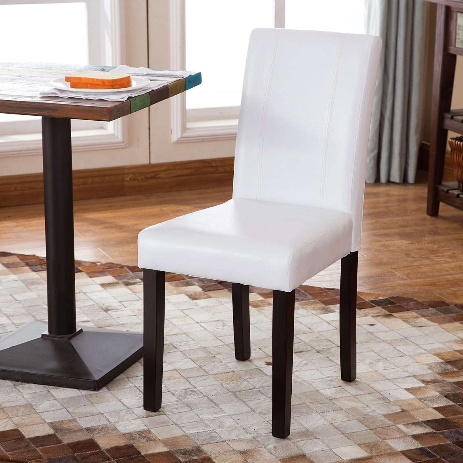 White chair with dark wooden legs in a dining room setting
