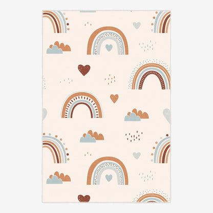 Patterned paper with rainbows, hearts, and clouds on a beige background