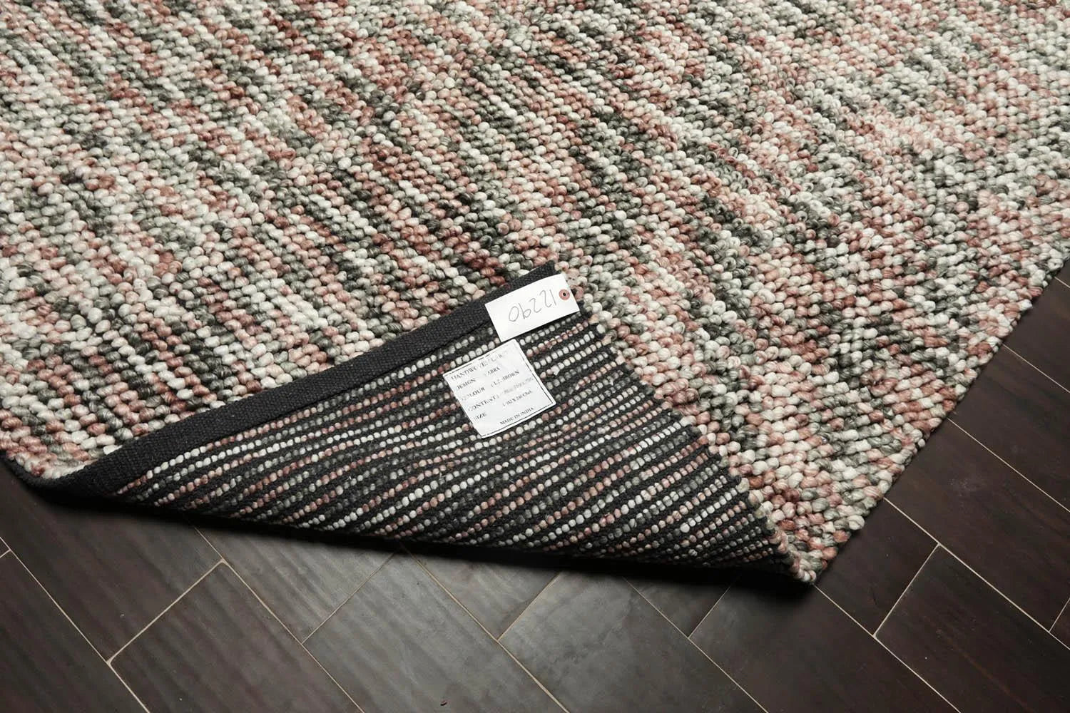 Textured rug with a brand label on a wooden floor