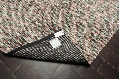 Textured rug with a brand label on a wooden floor