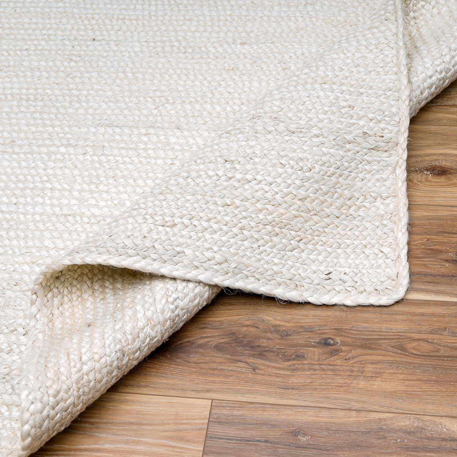 Close-up of a textured beige rug on a wooden floor