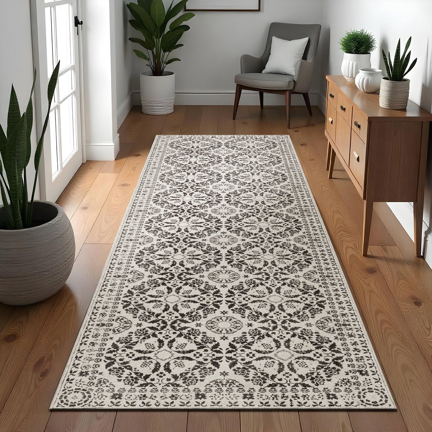Patterned rug on a wooden floor with a chair, cabinet, and plants in a room.