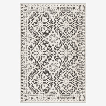 Decorative rug with a black and white pattern on a plain background