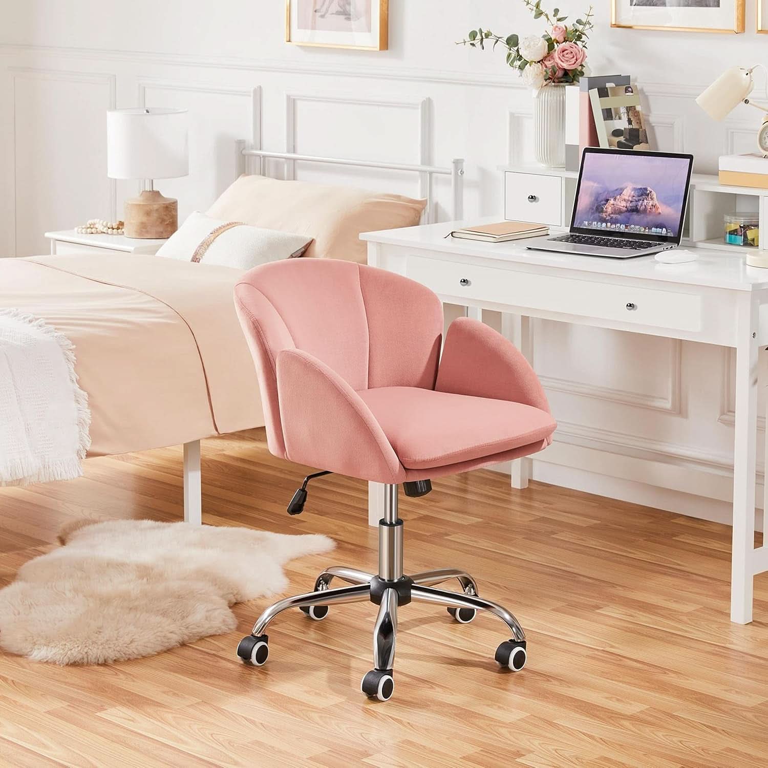 Pink office chair in a bedroom setting with a desk and laptop.