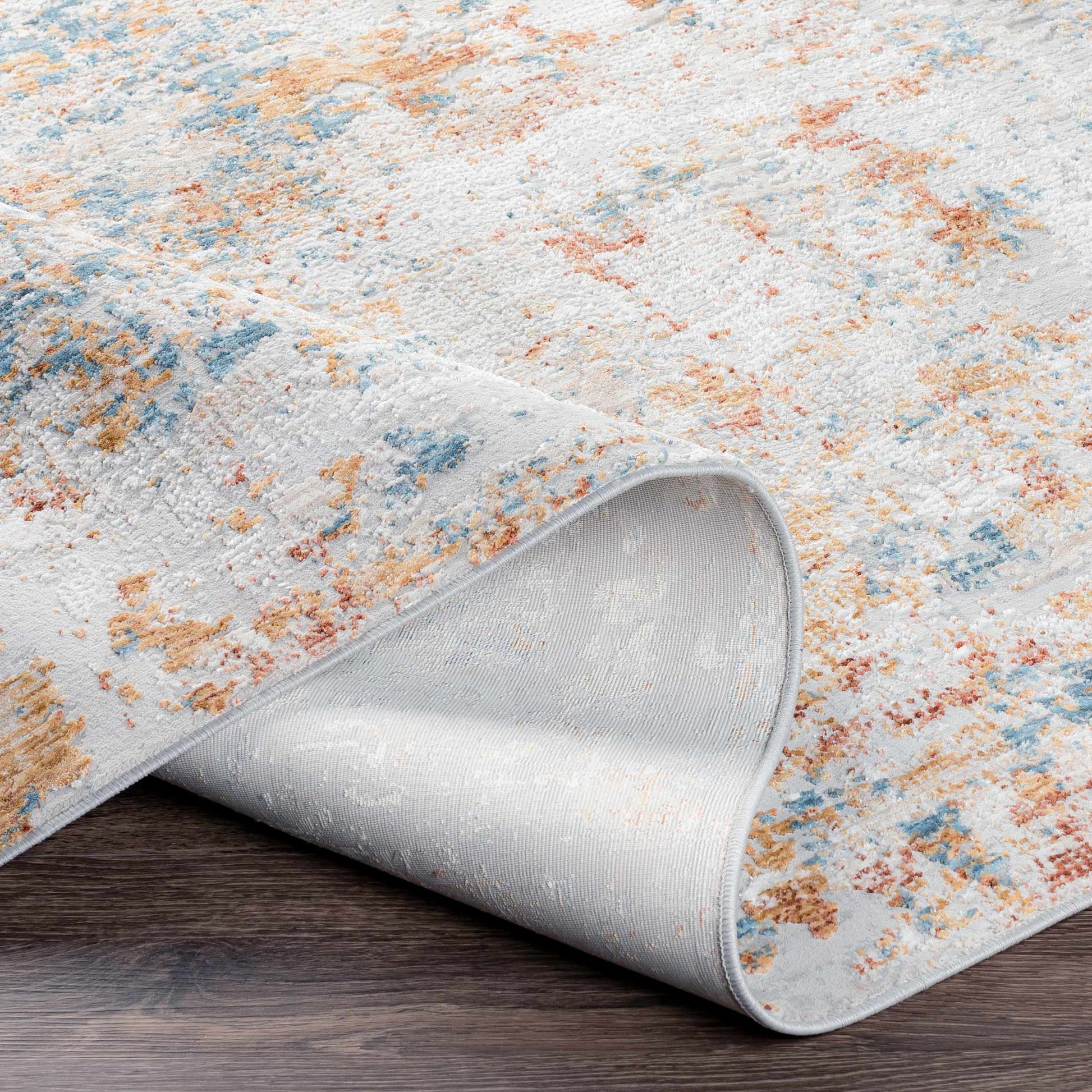 Rolled-up area rug with a textured pattern on a wooden floor