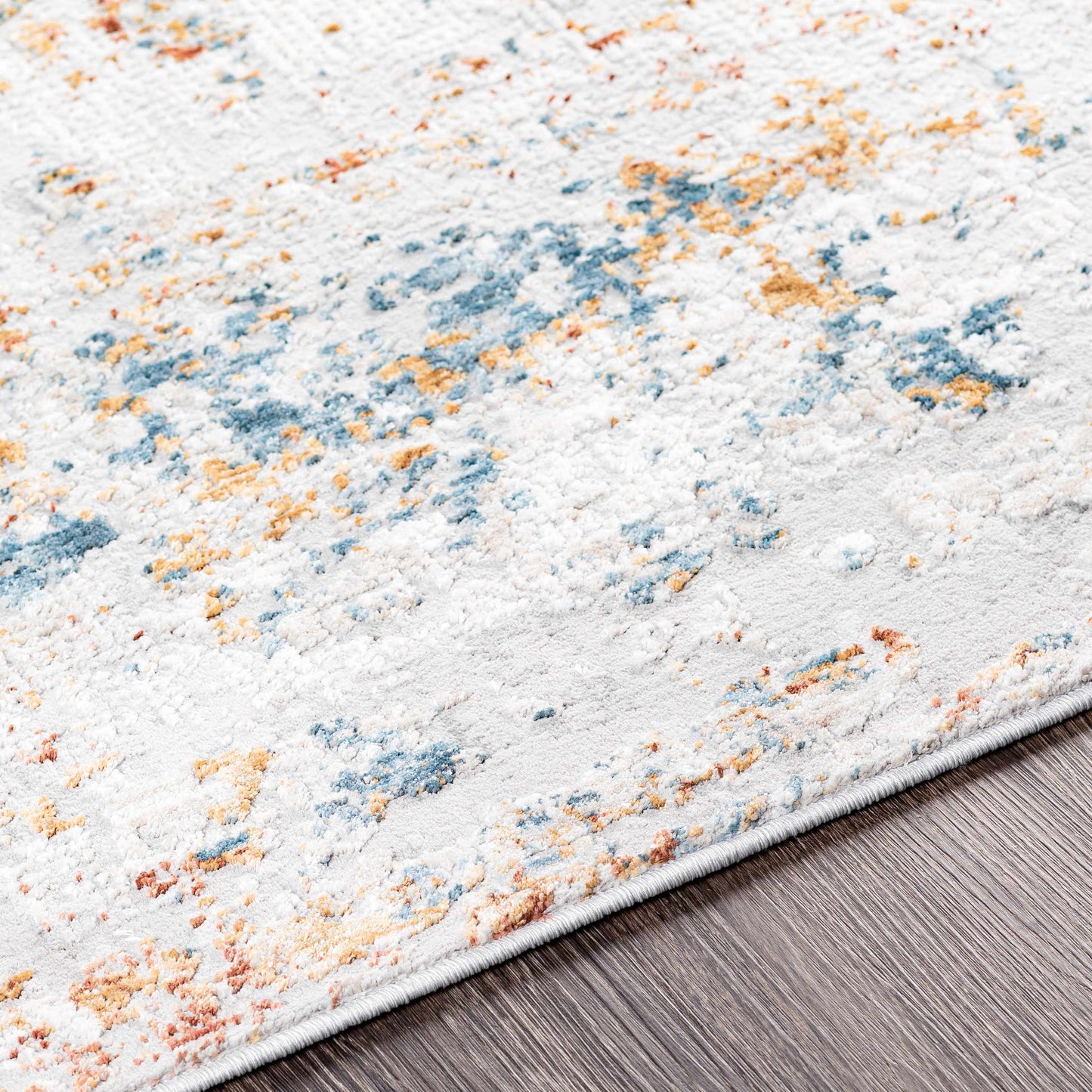 Textured area rug with multicolor pattern on a wooden floor