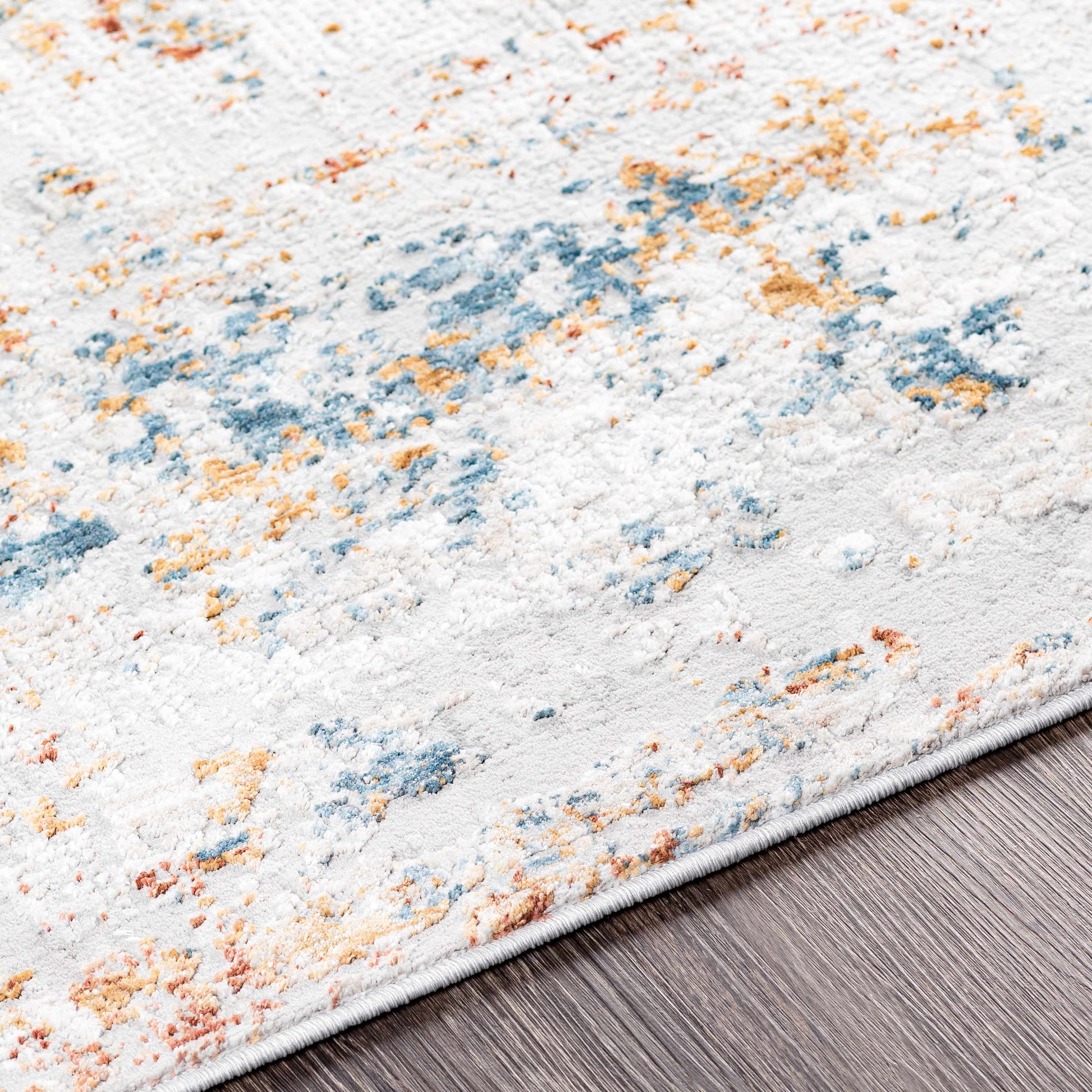 Textured area rug with multicolor pattern on a wooden floor