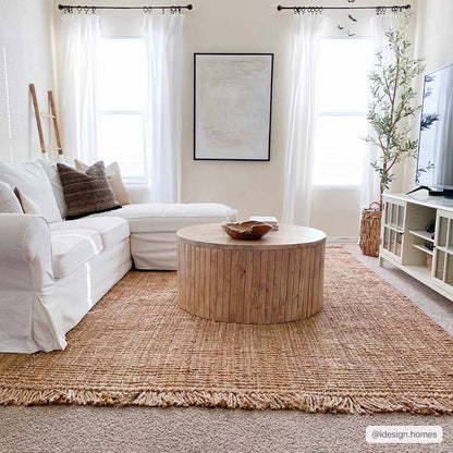Living room with white sofa, wooden coffee table, and large windows.