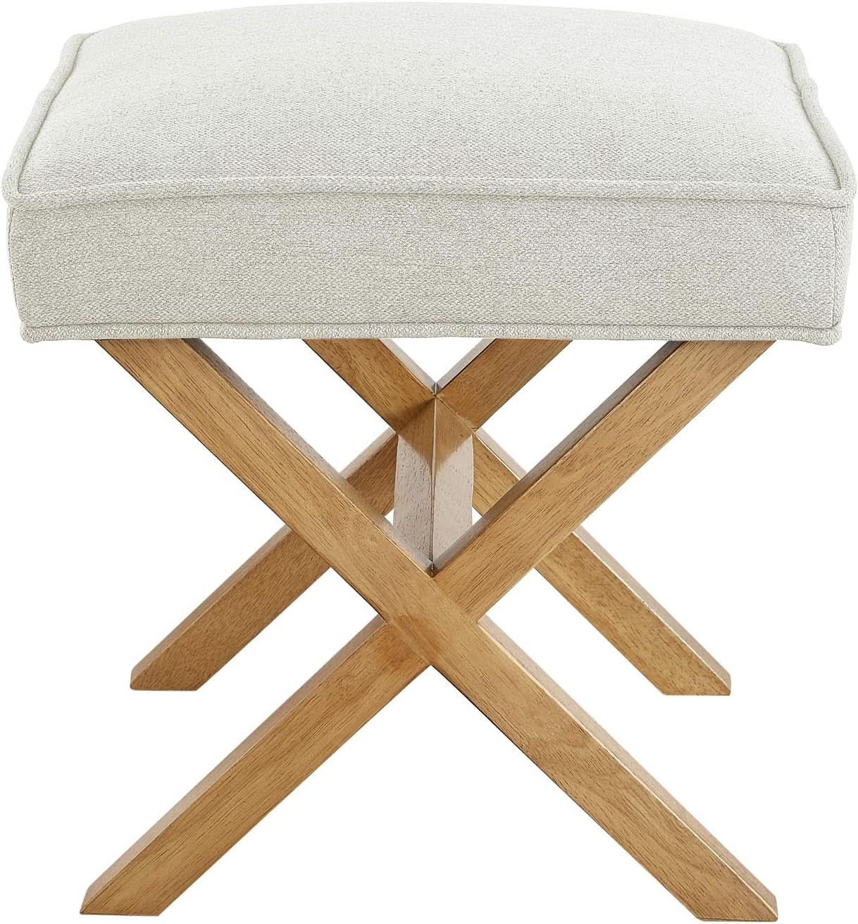 Stool with beige cushioned top and wooden cross-braced legs on a white background
