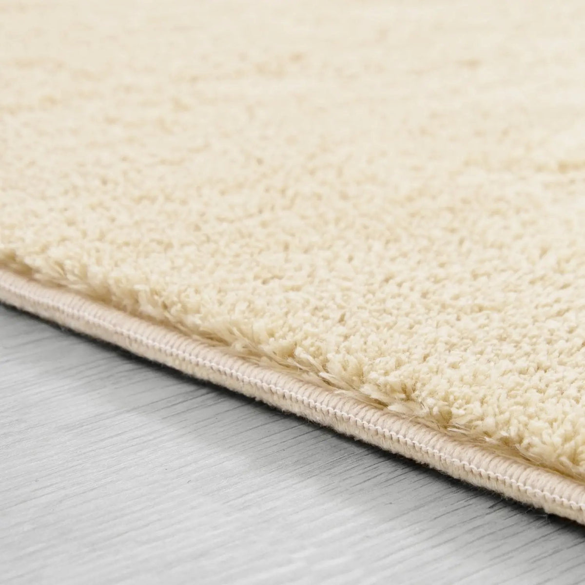Close-up of a beige rug on a wooden floor