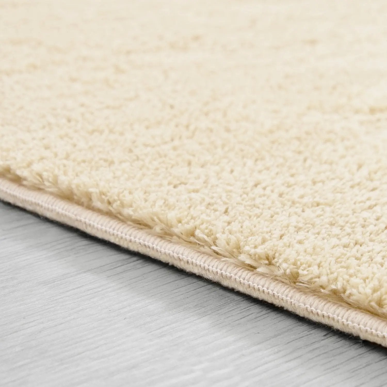 Close-up of a beige rug on a wooden floor