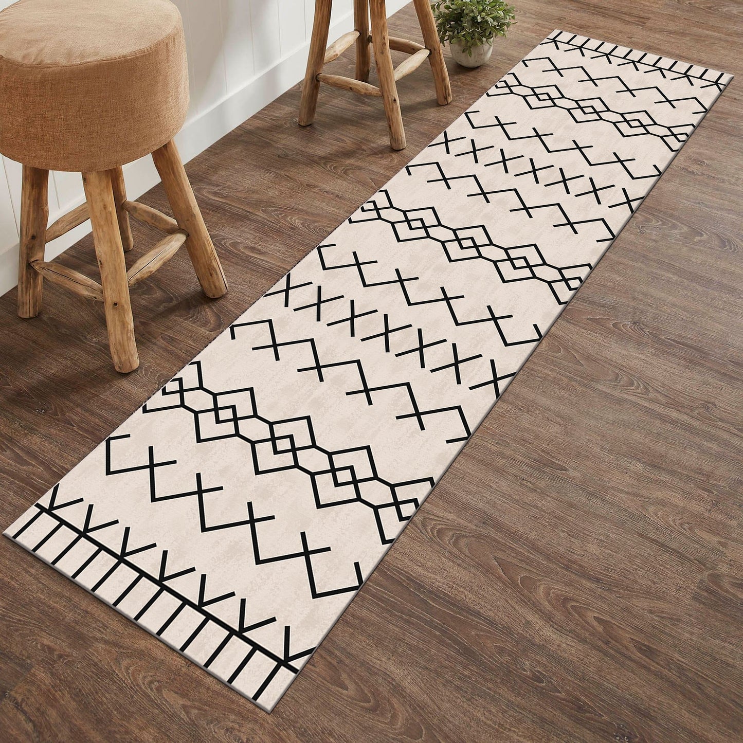 Long rectangular rug with black geometric pattern on a wooden floor