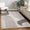Modern living room with a gray and white patterned rug on wooden flooring.