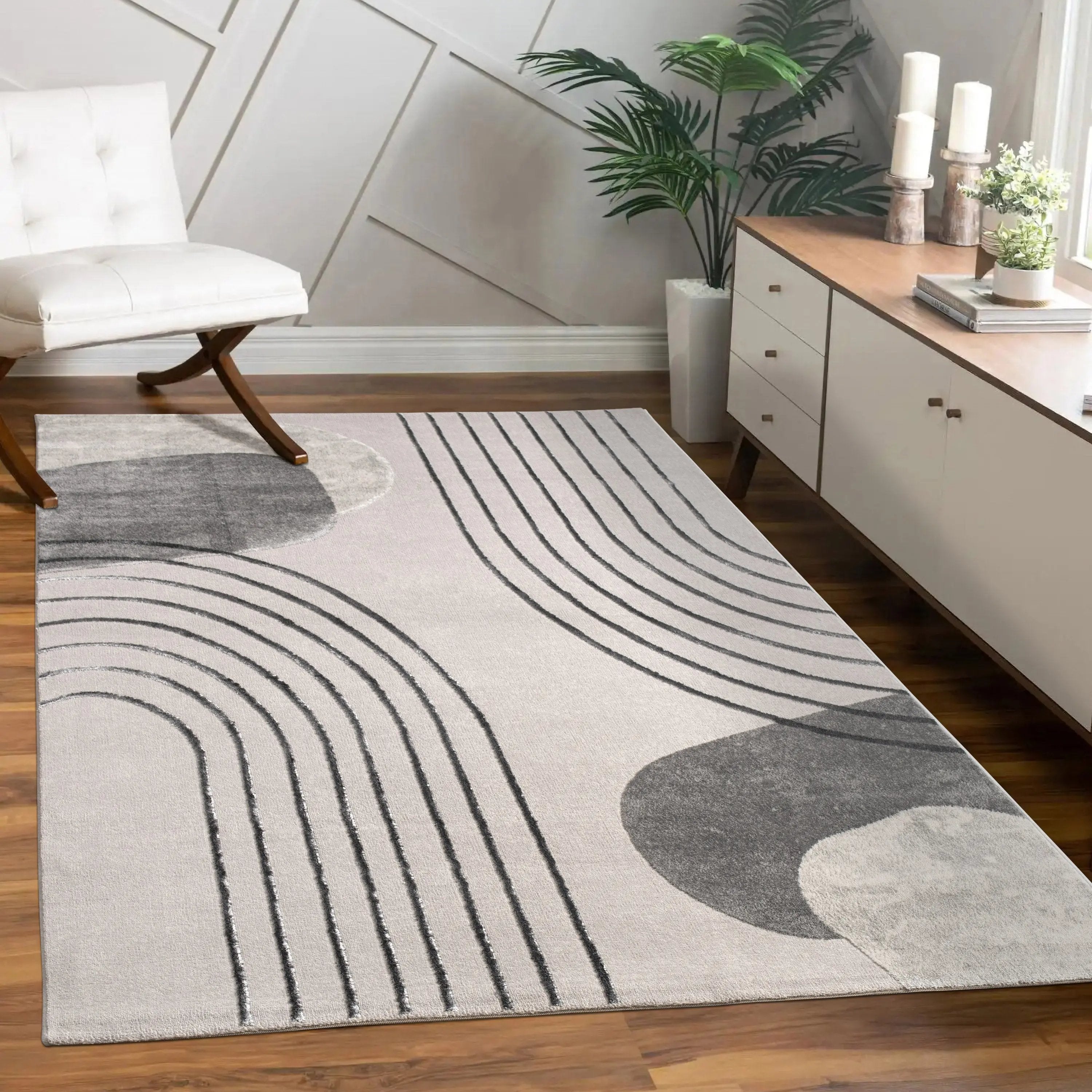 Modern living room with a gray and white patterned rug on wooden flooring.