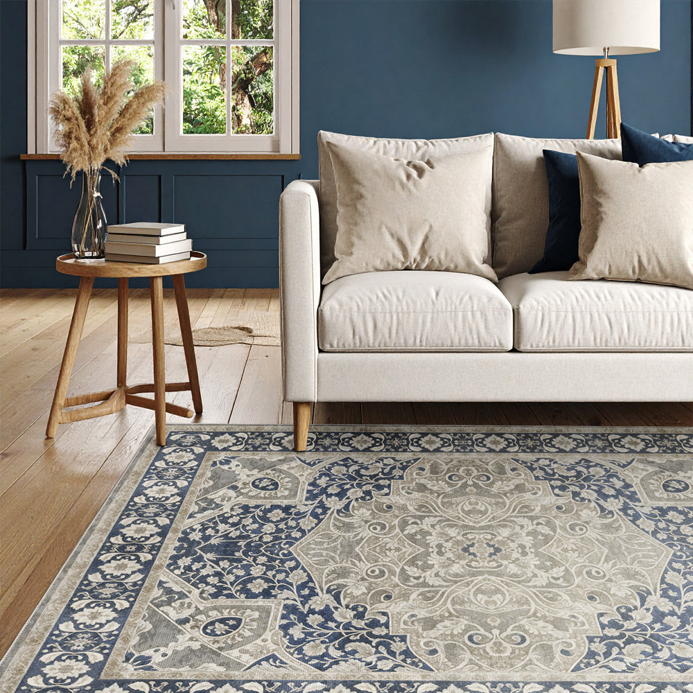 Living room with a patterned rug, beige sofa, and wooden side table.
